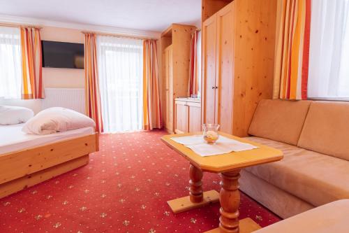 a hotel room with a bed and a table at Alpenpension Elferblick in Neustift im Stubaital