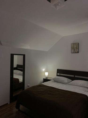 a bedroom with a large bed and a mirror at Belle View Apartment Sinaia in Sinaia
