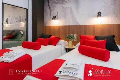 2 camas en una habitación de hotel con almohadas rojas en Urbanlux Olimpia Sleep & More, en Albacete