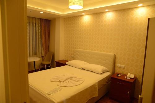 um quarto com uma cama com toalhas em Derya Hotel em Mersin