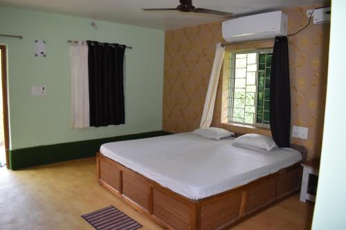 1 dormitorio con 1 cama grande y ventana en Kanikasundari Home Stay, en Bālianta