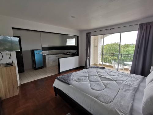 1 dormitorio con 1 cama grande y balcón en Chaweng Residence en Koh Samui