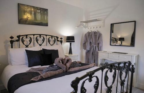 a bedroom with a black and white bed and a mirror at Lincoln Holiday Retreat Cottage with Private Hot Tub in Lincoln
