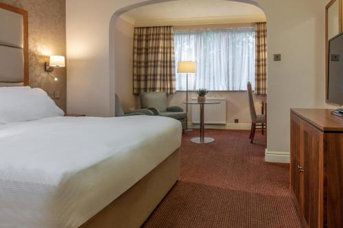 una camera d'albergo con letto e soggiorno di Stratford Manor Hotel a Stratford-upon-Avon