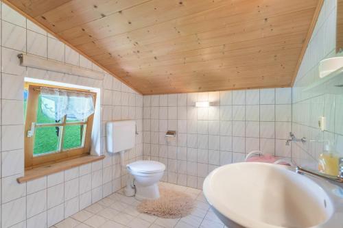 łazienka z toaletą, umywalką i oknem w obiekcie Ferienwohnung Spielberg w mieście Sankt Martin bei Lofer