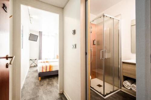 a bathroom with a glass shower and a sink at Hôtel PB - Paris-Barcelone in Perpignan