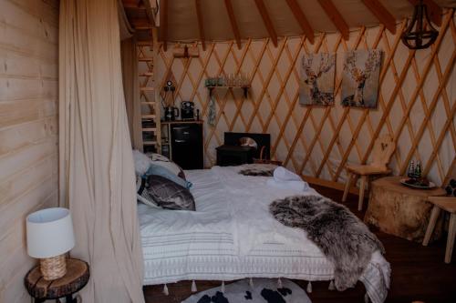 a bedroom with a bed in a tent at Jurty z widokiem, prywatna balia- DZIKOLAS GLAMPING in Krasnobród