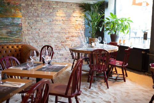 a restaurant with two tables and chairs and a brick wall at Babette Guldsmeden in Copenhagen