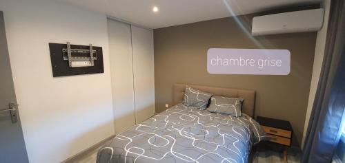 ein Schlafzimmer mit einem Bett und einem Schild an der Wand in der Unterkunft Agréable Villa pour 8 personnes in Pont-du-Château