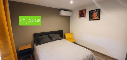 ein Schlafzimmer mit einem Bett und einem grünen Schild an der Wand in der Unterkunft Agréable Villa pour 8 personnes in Pont-du-Château