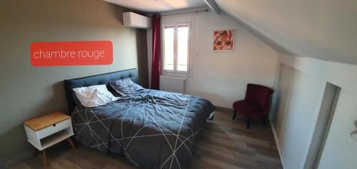 una camera con un letto e un cartello rosso sul muro di Agréable Villa pour 8 personnes a Pont-du-Château