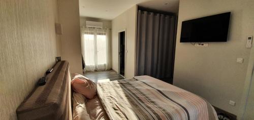 ein Schlafzimmer mit einem Bett und einem TV an der Wand in der Unterkunft Agréable Villa pour 8 personnes in Pont-du-Château