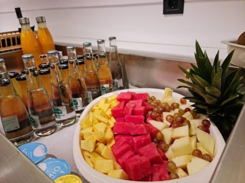 a bowl of fruit on a counter with a plate of food at Hotel Noy in Almuñécar