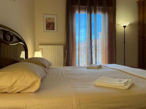 un grande letto bianco con due asciugamani sopra di [Apulian Heart] Elegante Appartamento a Gioia del Colle