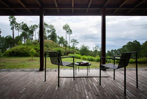 two chairs and a table on a patio at Amaya Life Kasauli in Kasauli