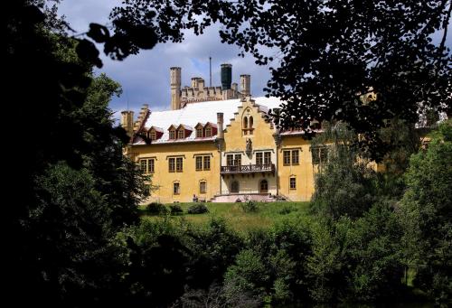 una gran casa amarilla con techo en Zámek Nečtiny, en Netschetin