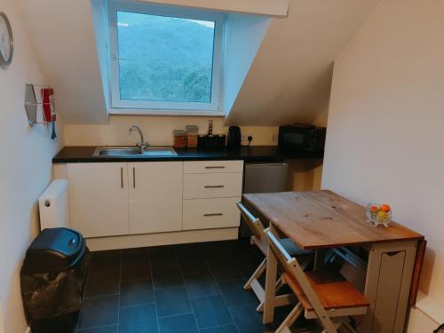 a kitchen with a table and a sink and a window at Pentre Cottage near Craig y Nos in Pen-y-cae