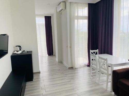 a living room with a white table and a chair at Wonderland in Chakvi