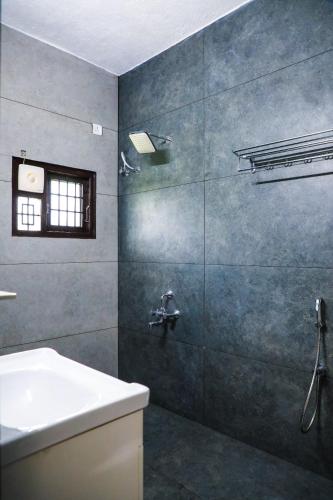 a bathroom with a shower with a sink and a tub at Castle home stays in Udupi