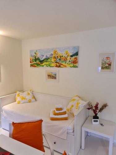 a white room with a bed and a table at Apartamentul ALB in Buşteni