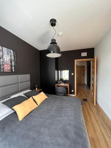 a bedroom with a large bed and a desk at Apartamenty BRUNO i BIANCA w Symphony Modern Tower Gdynia 2 i 3 piętro in Gdynia
