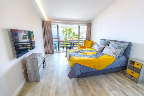 a bedroom with a bed and a balcony at Vista Oceano III in Caniço