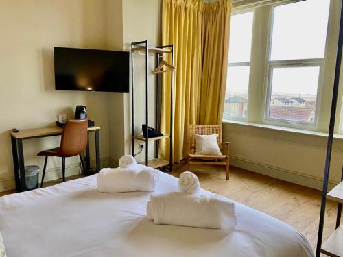 安斯特拉瑟Balcomie Links Hotel的酒店房间里有一张床，上面放着毛巾