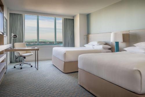 a hotel room with two beds and a desk at Hyatt Regency Jacksonville Riverfront in Jacksonville