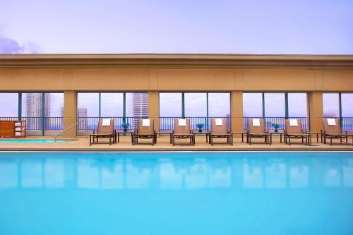 a hotel with a pool with chairs and windows at Hyatt Regency Jacksonville Riverfront in Jacksonville