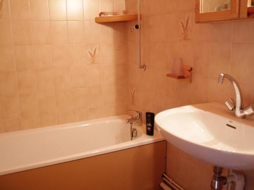 een badkamer met een wastafel en een bad naast een wastafel bij Appartement Châtel, 3 pièces, 6 personnes - FR-1-200-299 in Châtel