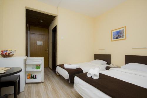 a hotel room with two beds and a desk at Guesthouse Junior in Kopaonik