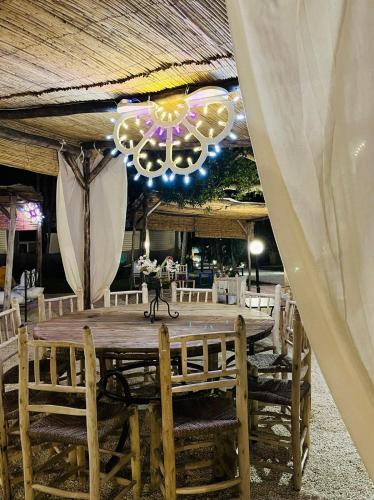 a large wooden table with chairs and a chandelier at Baia Dei Micenei in Otranto