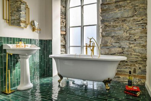 a bathroom with a white tub and a sink at Finest Retreats - Luxury Converted Chapel with Hot Tub & Games Room in Dinas Mawddwy
