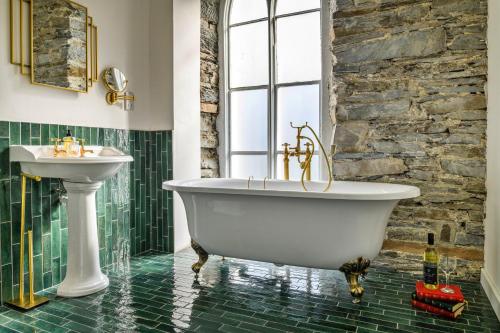 Un baño con bañera blanca y lavabo. en Finest Retreats - Luxury Converted Chapel with Hot Tub & Games Room, en Dinas Mawddwy
