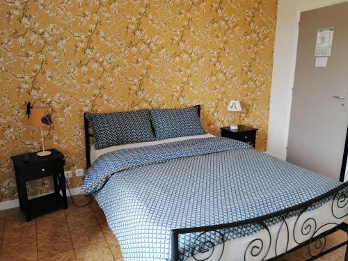 a bedroom with a bed with a floral wallpaper at LE RELAIS DE LA FONTAINE in Échandelys