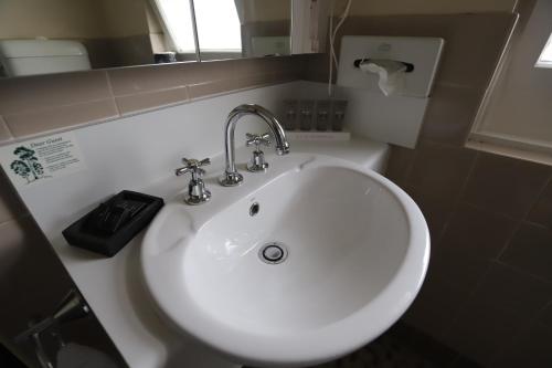 a white sink in a bathroom with a mirror at Townhouse Motel Cowra in Cowra