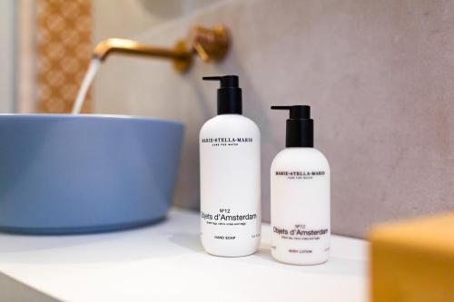 a couple of bottles of shampoo sitting on a counter at Vie Via - Your Hotel in Leeuwarden