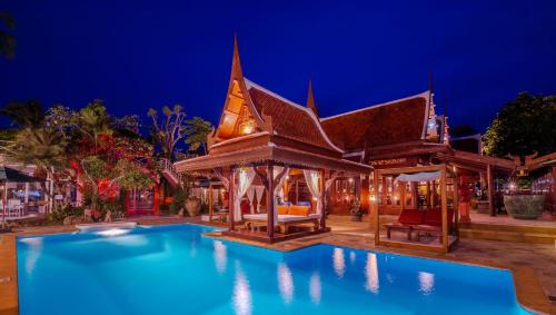 Royal Thai Villa Phuket - SHA Extra Plus في شاطئ راوايْ: منتجع فيه مسبح بالليل