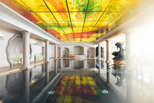 Habitación con techo pintado y piscina de agua. en Hotel Steiner Superior, en Obertauern