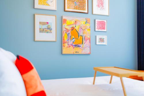 a room with paintings on the wall and a table at Vie Via - Your Hotel in Leeuwarden