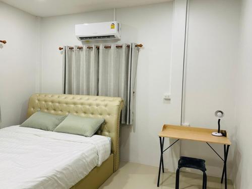 a bedroom with a bed and a table and a heater at Phu Thai Resort in Sukhothai