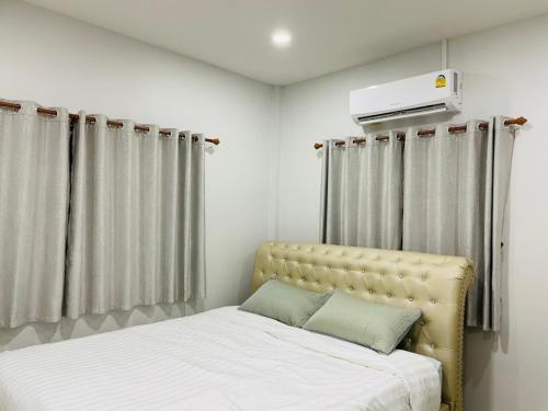 a bedroom with two beds and a heater on the wall at Phu Thai Resort in Sukhothai