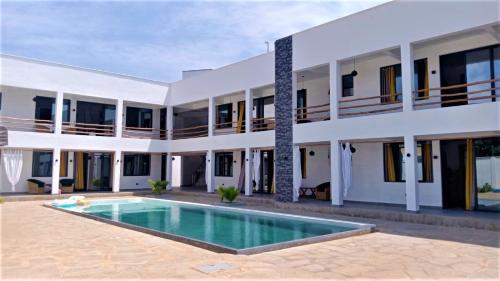 a building with a swimming pool in front of it at V-Szameitat Homes, Kongo River in Diani Beach