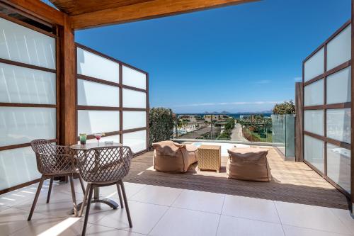 a balcony with a table and chairs and a view at Astir Odysseus Kos Resort and Spa in Tigaki