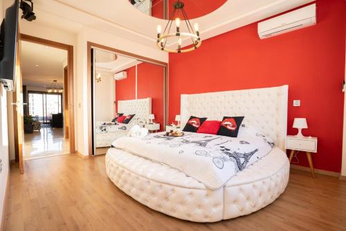 a bedroom with a large white bed with red walls at La cascade de Maryline in Casablanca
