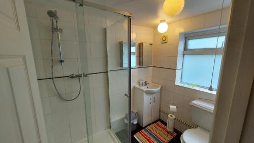 a bathroom with a shower and a toilet and a sink at Gillings Villa -5 Bed Great For Long & Short Stay!!! Gillingham Kent in Hoo