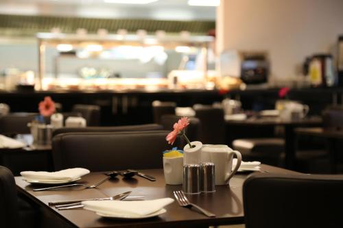 a table with a flower on it in a restaurant at Ramada Oxford in Waterstock
