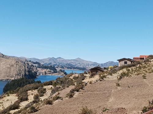 a house on the side of a hill overlooking a river at Ecolodge El descanso in Comunidad Yumani