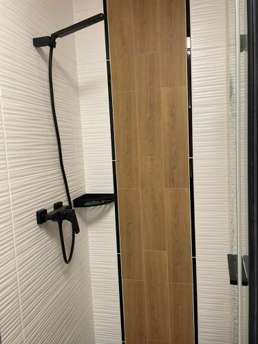 une douche avec une porte blanche et une pomme de douche dans l'établissement Apartament Kasprowicza, à Kołobrzeg