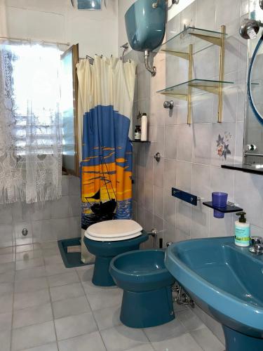 a bathroom with a blue toilet and a sink at Casa Celestina in Marina di San Lorenzo